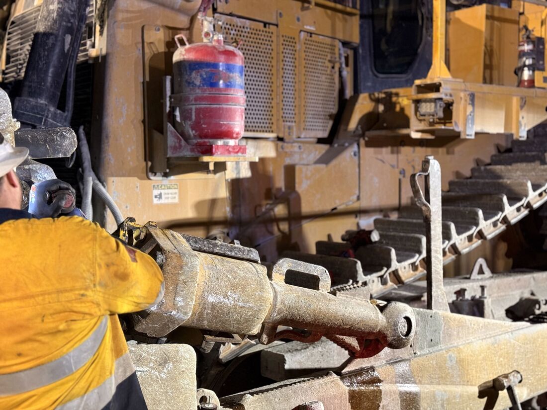 Fitter working on a dozer blade and ripper assembly on site