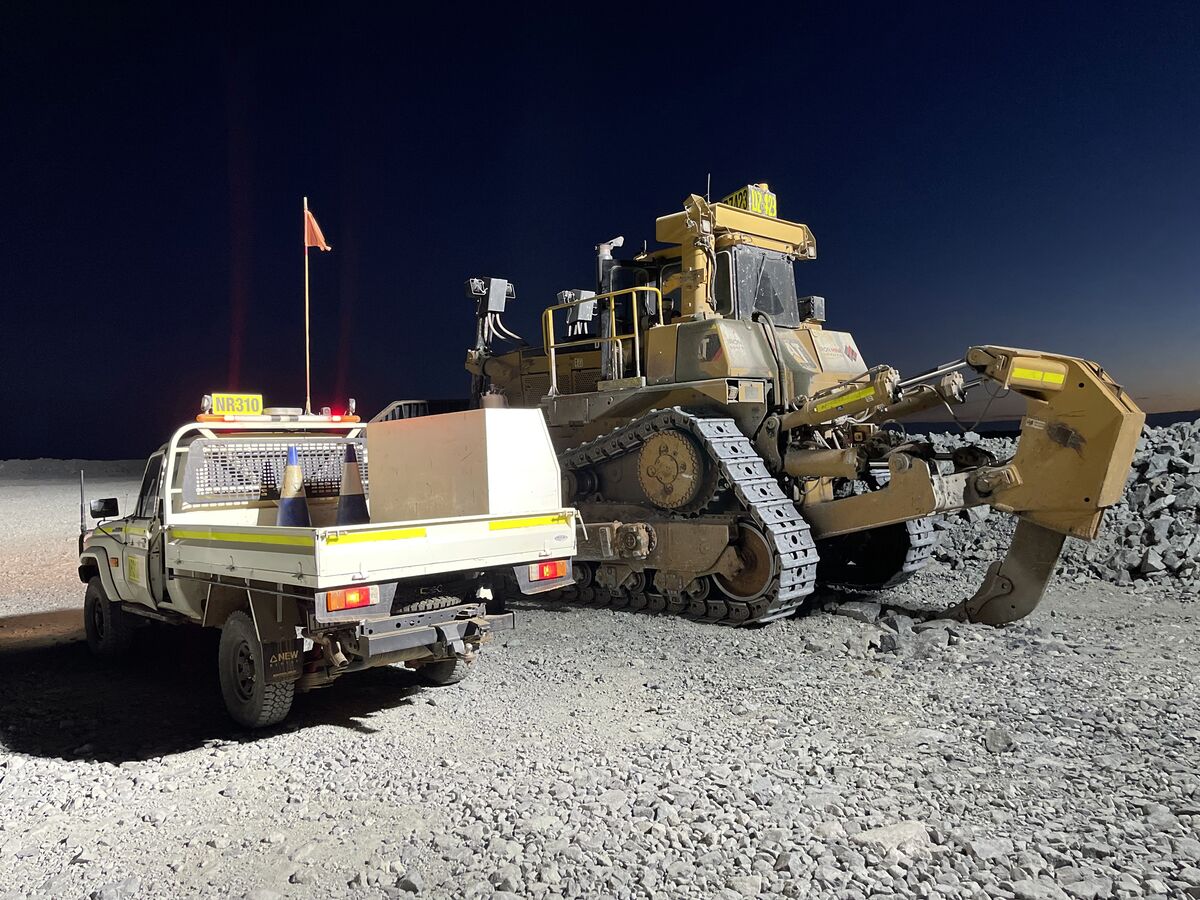 Service ute parked beside a dozer on a mine site at night