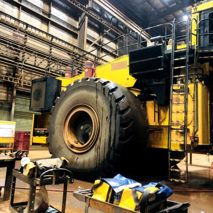 Haul truck with a wheel removed in a heavy machinery workshop